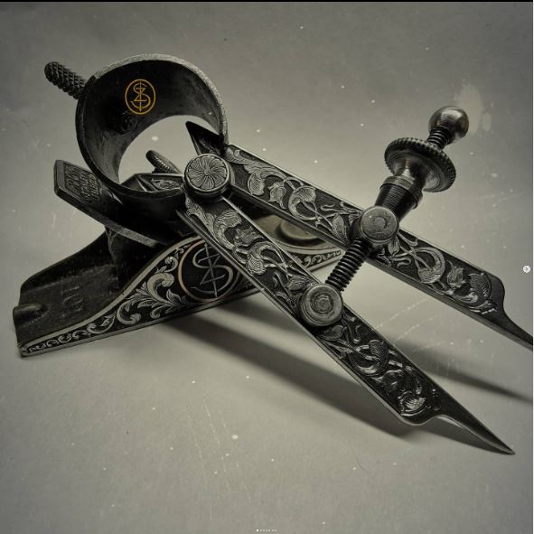Kézzel vésett acél körző és asztalos gyalu részletgazdag ornamentikus mintákkal. Egyedi művészi díszítés és szerszám design.